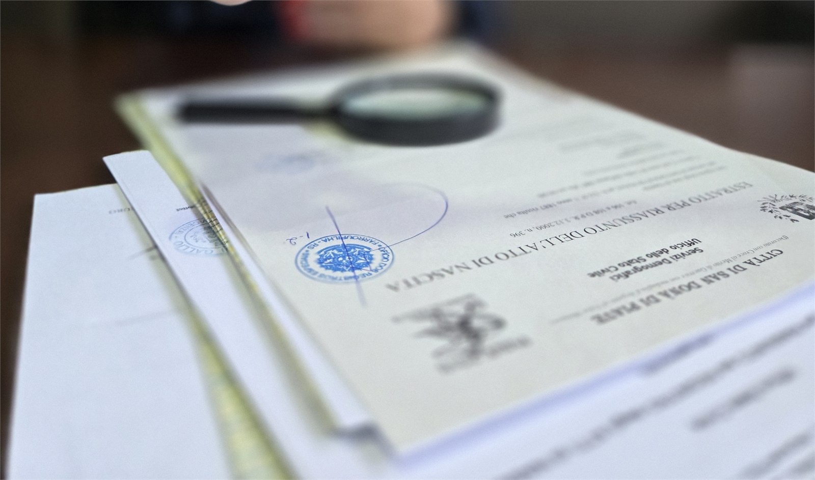Certidões, documentos e lupa utilizados em análise documental